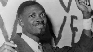 A vintage black-and-white photo of Patrice Lumumba addressing a crowd during Congo’s independence movement.