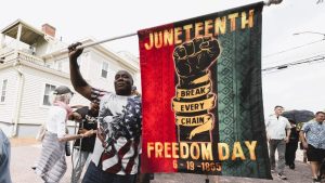 Community members gathered around a memorial during a Juneteenth ceremony at the African Burying Ground in Portsmouth, New Hampshire.