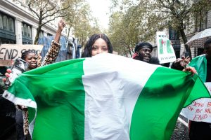 Protesters march in Lagos during Nigeria’s Democracy Day, holding placards and demanding economic reforms.
