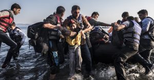 A row of discarded life jackets left behind by refugees on the shores of Lesbos, symbolizing a decade of migration and memory.