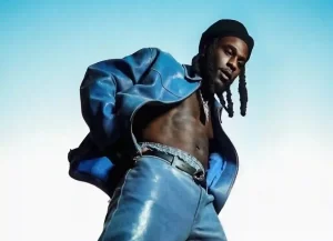 Burna Boy performing on stage with vibrant lighting during a live show.