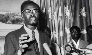 A vintage black-and-white photo of Patrice Lumumba addressing a crowd during Congo’s independence movement.