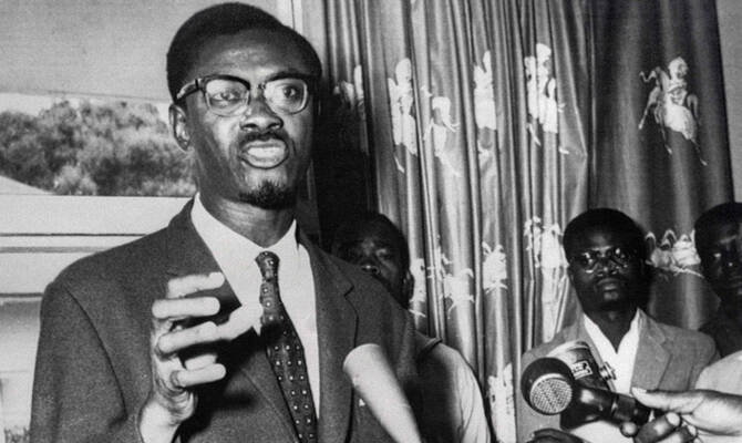 A vintage black-and-white photo of Patrice Lumumba addressing a crowd during Congo’s independence movement.