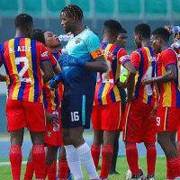 Accra Hearts of Oak players during a team huddle at the Accra Sports Stadium before a match.