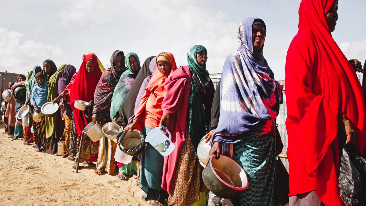 Displaced Sudanese civilians receive food aid in a camp affected by armed conflict and food insecurity.