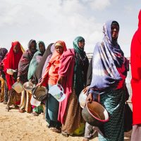 Displaced Sudanese civilians receive food aid in a camp affected by armed conflict and food insecurity.