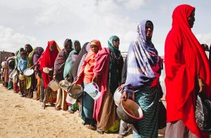Displaced Sudanese civilians receive food aid in a camp affected by armed conflict and food insecurity.