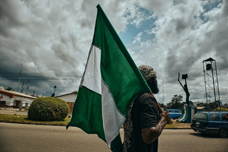 Protesters march in Lagos during Nigeria’s Democracy Day, holding placards and demanding economic reforms.