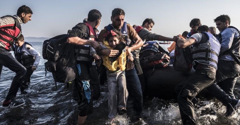 A row of discarded life jackets left behind by refugees on the shores of Lesbos, symbolizing a decade of migration and memory.