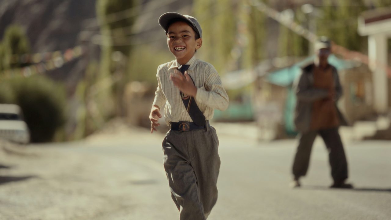 A young teenage boy walking alone with a school bag, symbolizing separation and forced relocation.