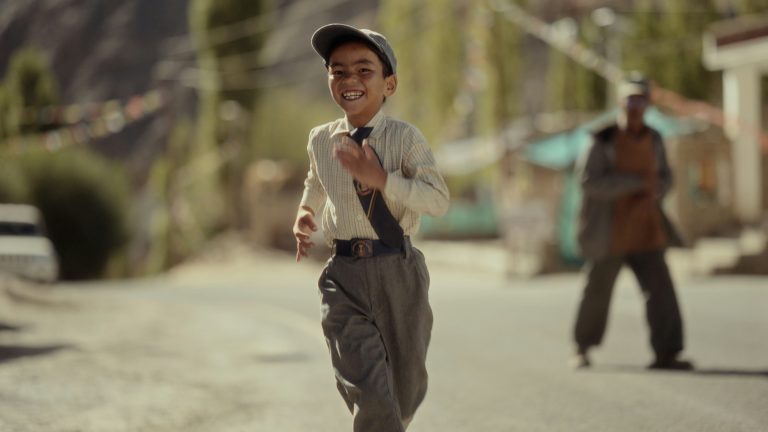 A young teenage boy walking alone with a school bag, symbolizing separation and forced relocation.