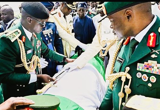 A crowd of mourners surrounds the hearse carrying the body of former Nigerian president Muhammadu Buhari in Daura.
