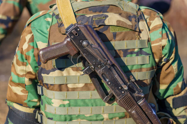 An armed M23 rebel patrols a dirt road in eastern DR Congo as peace negotiations loom in Doha.