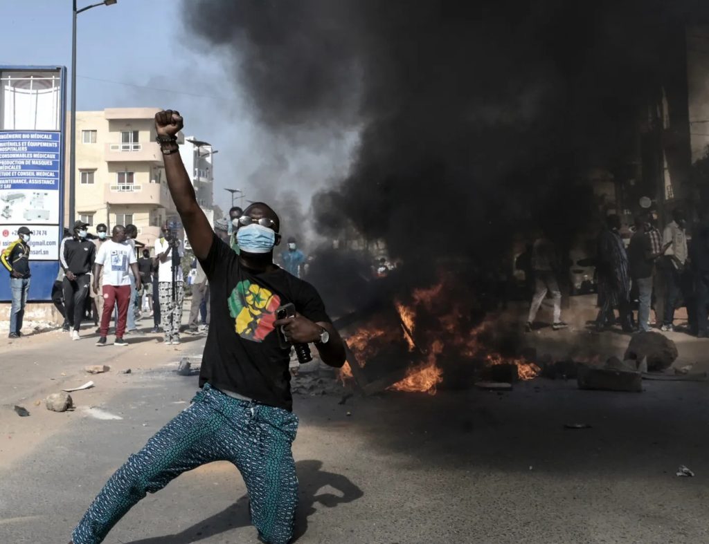 Senegalese protestors facing police during political unrest in Dakar, 2021
