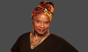 Angélique Kidjo smiling at an award ceremony wearing traditional African attire.