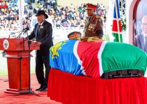 A Namibian flag waves beside a cemetery during a state funeral service.