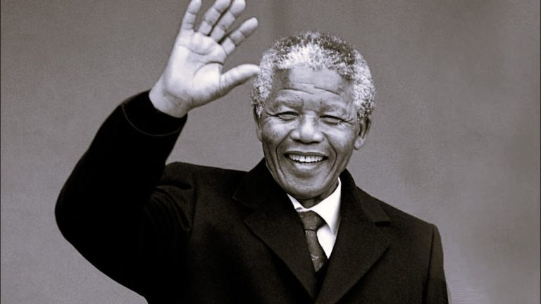 A tribute event held on Nelson Mandela International Day 2025, with people holding posters of Mandela and volunteering in community service, symbolizing global unity and the fight against poverty.