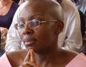 Rwandan opposition leader Victoire Ingabire standing in court, facing judges during her bail hearing in Kigali, as supporters and legal staff observe.