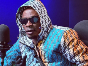 Shatta Wale performing on stage at the Accra Sports Stadium during the 2025 President’s Cup, surrounded by dancers and lights.
