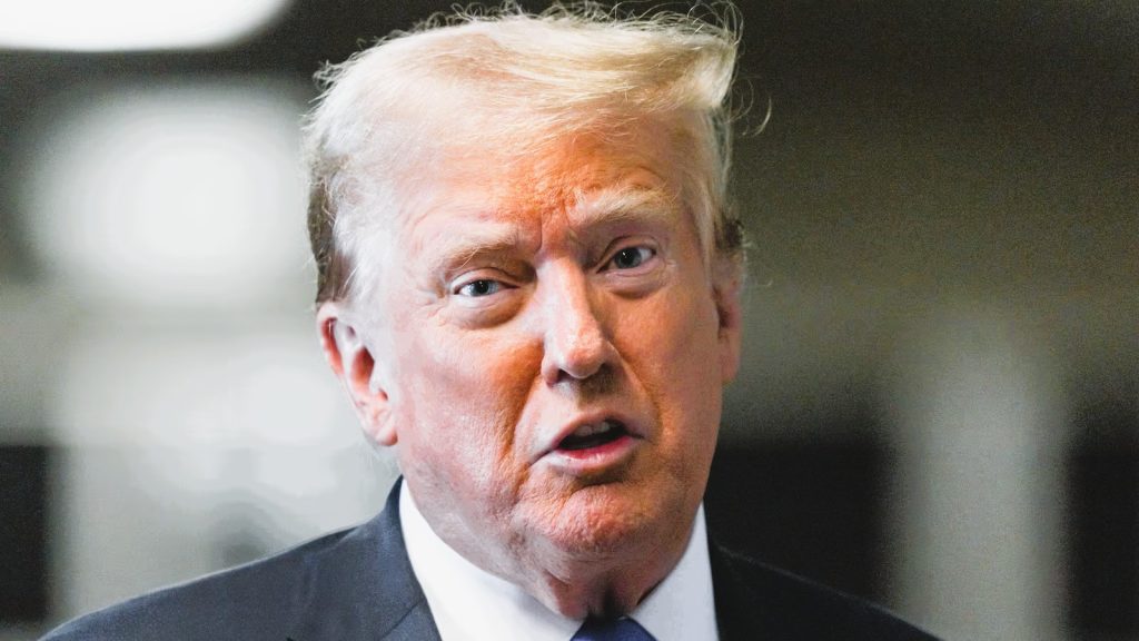 Former US President Donald Trump speaks at press conference announcing new tariff policy with US flags in the background.